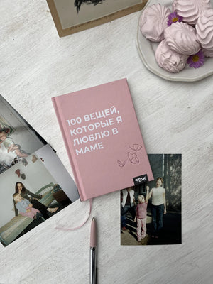 Розовая книга «100 вещей, которые я люблю в маме» на столе с фотографиями