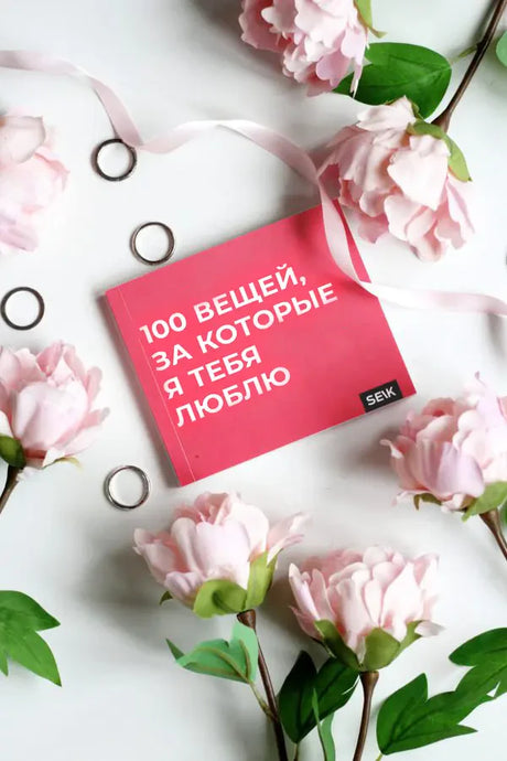 Книга «100 вещей, за которые я тебя люблю» среди розовых цветов