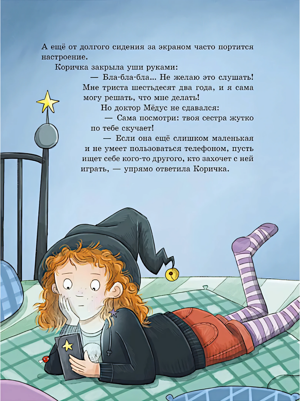 Девочка в колпаке лежит на кровати и смотрит в телефон.