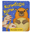 Обложка книги «Капибара Капи» с капибарой и жёлтой лентой.