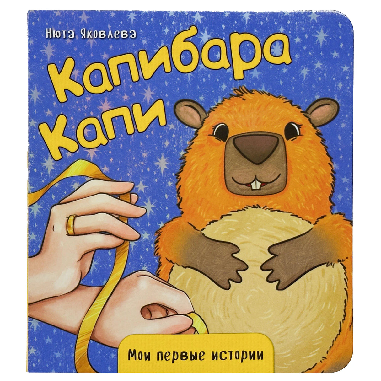 Обложка книги «Капибара Капи» с капибарой и жёлтой лентой.