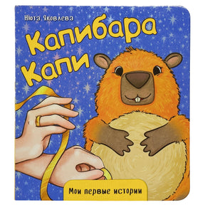 Обложка книги «Капибара Капи» с капибарой и жёлтой лентой.