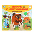 Книга с липучками «Любимые герои» издательства Умка — детские руки держат книгу с персонажами Союзмультфильма
