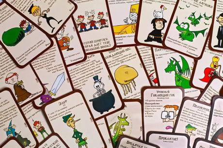 Крупный план карт Манчкина, веером разложенных на тёмной поверхности: монстры, классы, предметы