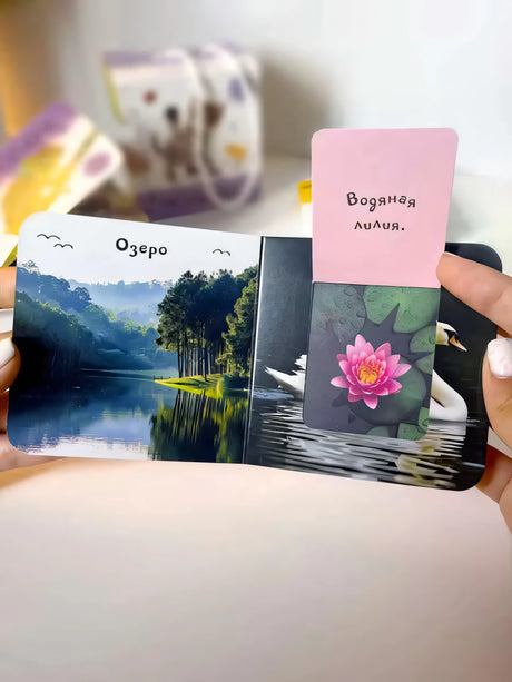 Книга «Природа» в руках: разворот с озером, открытый клапан «Водяная лилия» с фото лотоса и лебедя