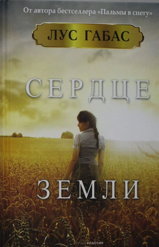 Обложка романа Лус Габас «Сердце земли»: женщина стоит в пшеничном поле.