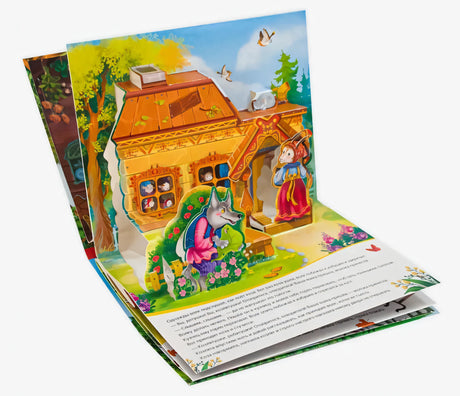 Разворот pop-up книги: объёмная сцена с домиком, волком у входа и козой; видны страницы и корешок
